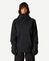 Kvinna iklädd Houdini Rollercoaster Jacket II i färgen True Black med tillhörande skidbyxor och svarta handskar.