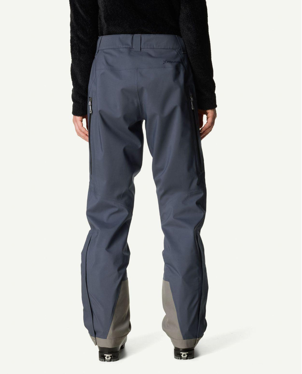 Houdini Ride Pants II dam i blått sett bakifrån buret med skidpjäxor.