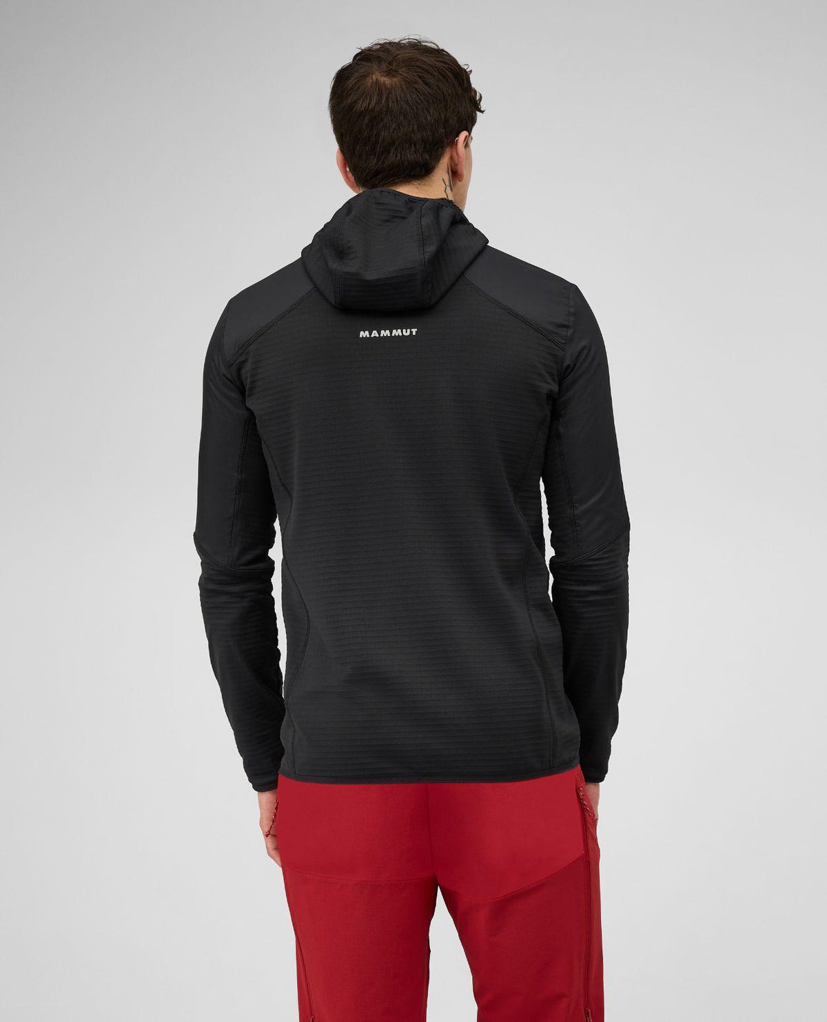 Mammut Aenergy ML Hybrid Hooded Jacket Men i svart sett bakifrån på skidåkare.