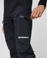 Närbild på person som drar igen fickblixtlåset på de svarta skidbyxorna Mammut Eiger Free Pro HS Bib Pants.