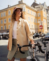 Elevenate Utility Shirt i safari beige bärs som överskjorta utomhus med cykel i stadsmiljö.