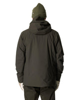 Baksidesvy på en man som bär Houdini Ride Insulated Jacket i färgen grön illusion och matchande mössa.