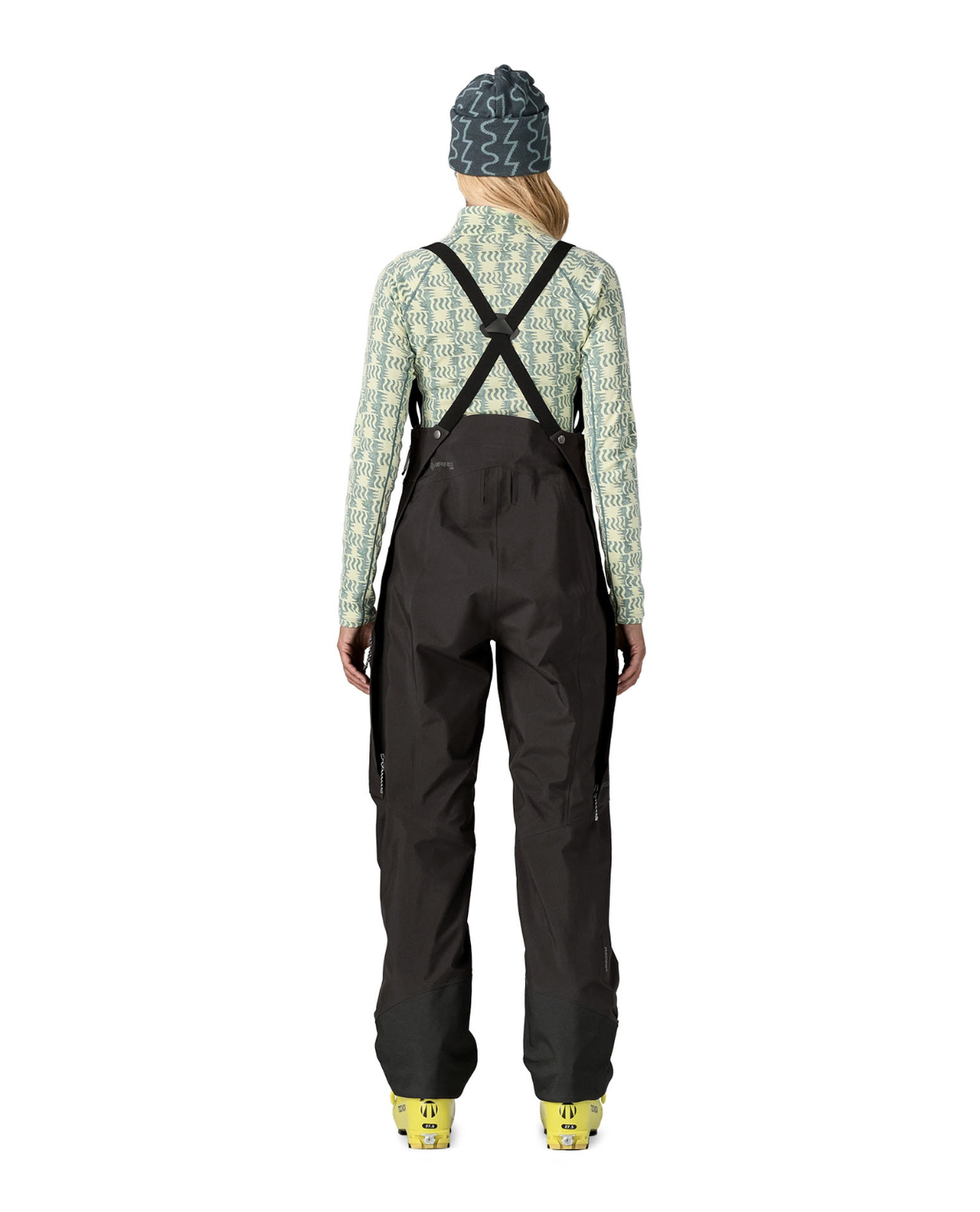 Patagonia PowSlayer Bibs Women i svart färg visade bakifrån på skidåkare.
