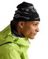 Arc'teryx Grotto Toque i svart och grått på modell som bär ljusgrön jacka.