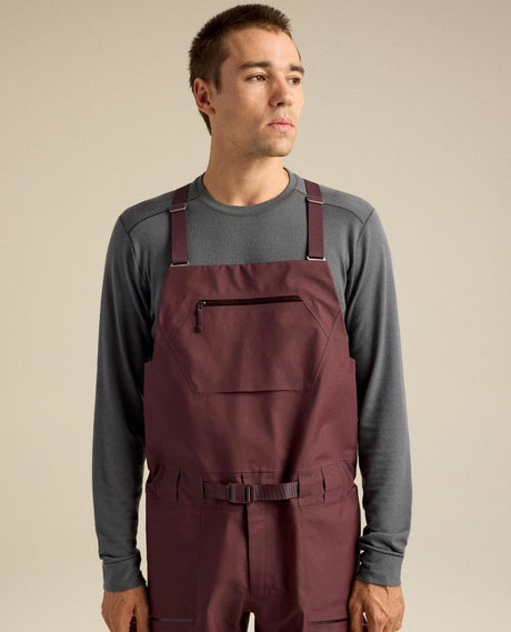 Man i lila hängselbyxor i modellen Arc'teryx Sabre Bib Men i färgen Ultima.
