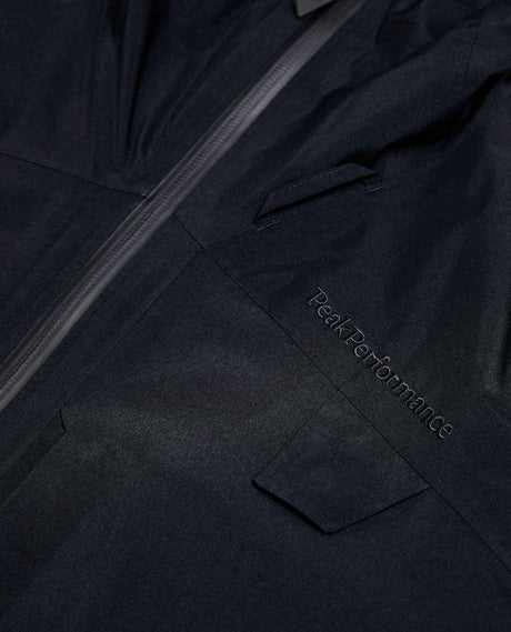 Närbild på den svarta skidjackan Alpine Gore-Tex Insulated Jacket från Peak Performance med broderad logotyp.