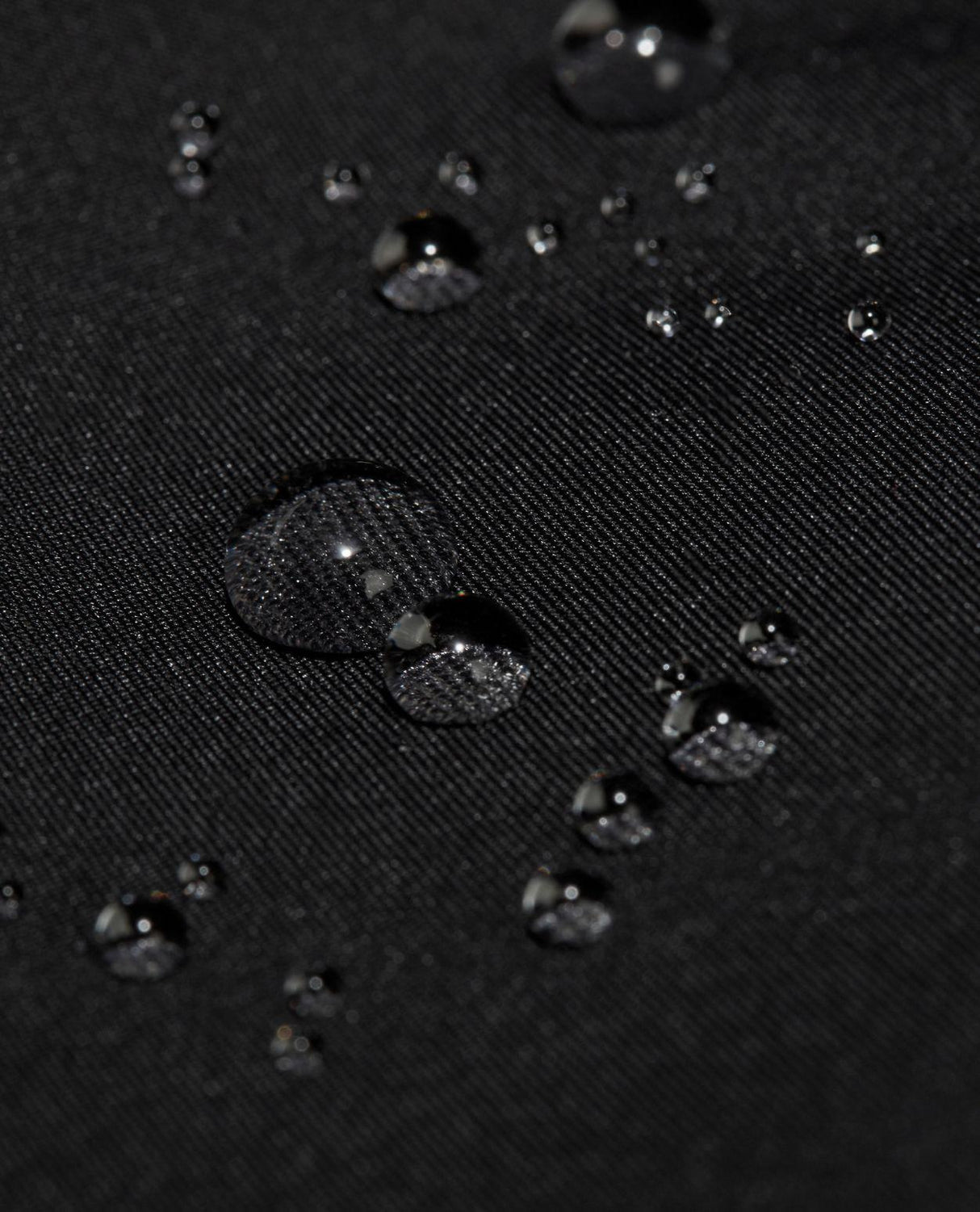 Vattendroppar på det svarta hardshell-materialet till Mammut Haldigrat HS Hooded Jacket