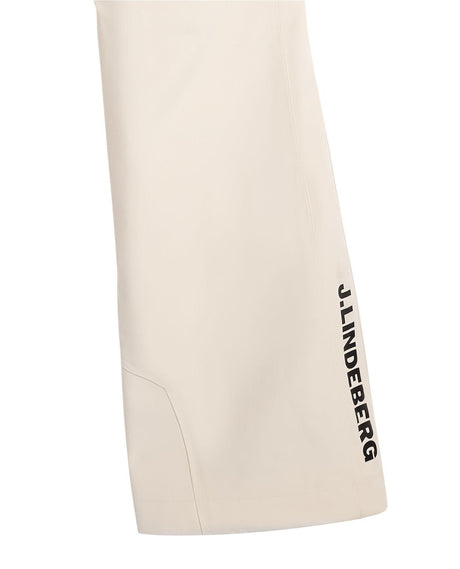 Närbild på benet av J.Lindeberg Elara skidbyxor i färgen moonbeam beige med svart logotyp.