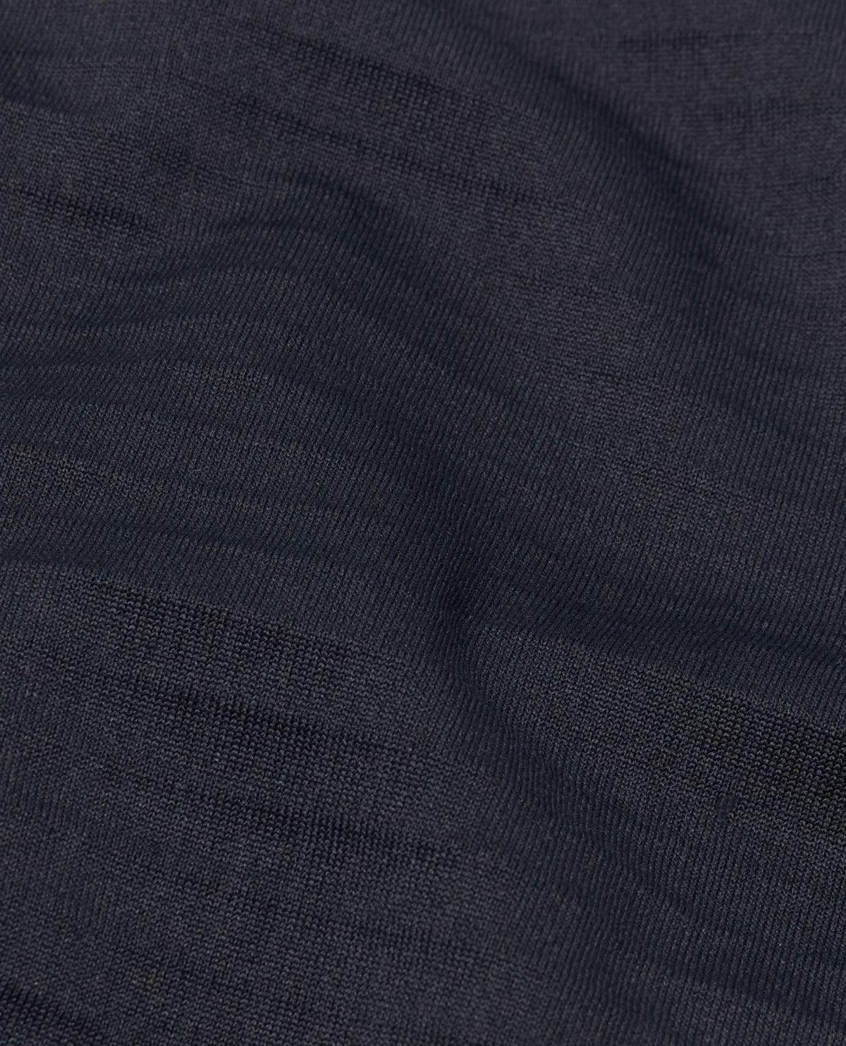 Närbild på det svarta funktionsmaterialet hos Mammut Aenergy ML Hybrid Hooded Jacket för herrar. Alpingaraget