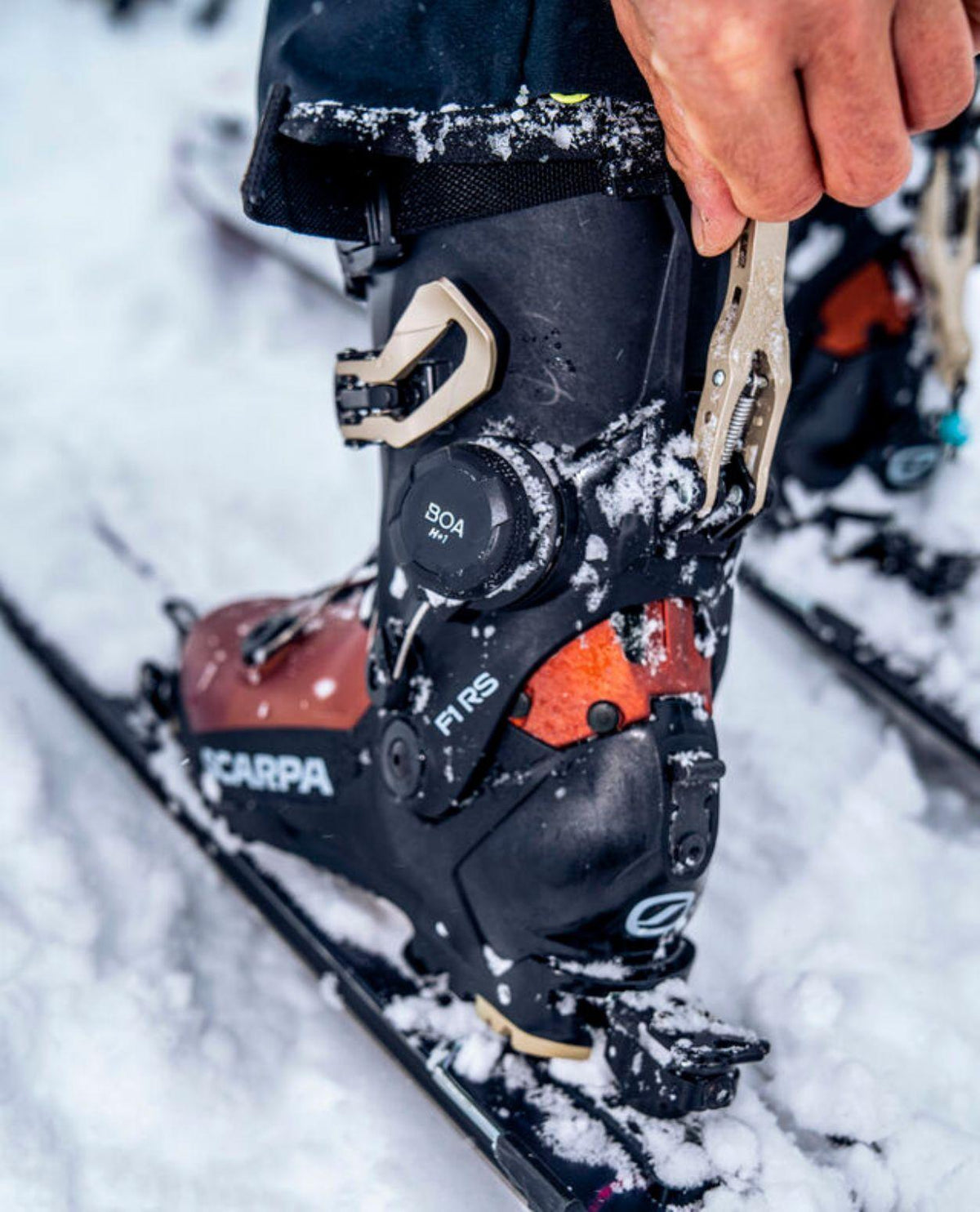 Scarpa F1 RS brun toppturspjäxa med BOA-system och gåläge i snömiljö.